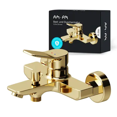 A golden bathtub faucet is shown in front of its packaging.