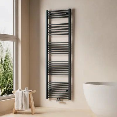 A modern bathroom with a dark grey towel radiator, a wooden stool with towels, and a white bathtub.