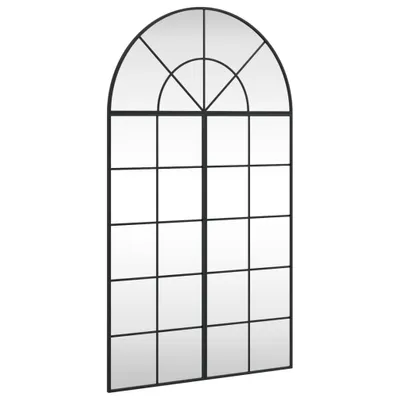 A full-shot of a black arched window mirror against a white background.