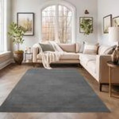 A living room with a sectional sofa and a rug.