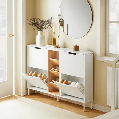 A hallway or entryway with a shoe cabinet, mirror, and decorative items.