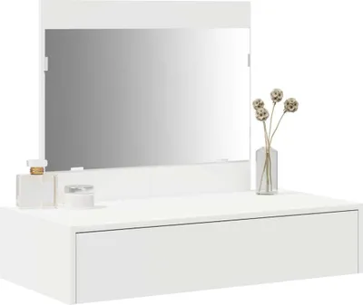 A white dressing table with a mirror and a drawer, decorated with a perfume bottle, a jar, and a vase with dried flowers.
