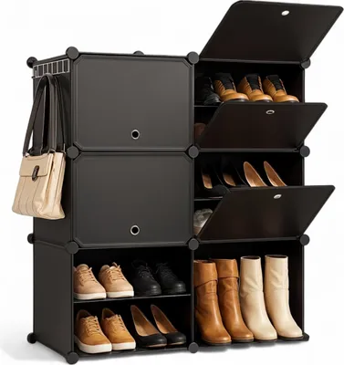 A black modular shoe cabinet filled with various shoes and boots, with a beige handbag hanging on the side.