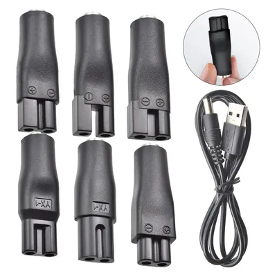 A collection of black electronic adapters and a USB charging cable are arranged on a white background.