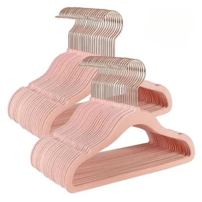 A stack of pink velvet hangers with rose gold hooks against a white background.