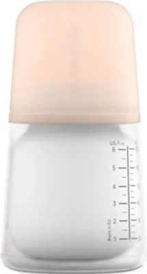 A baby bottle with a peach-colored cap.