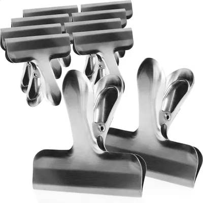 A group of stainless steel bag clips arranged on a white background.
