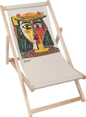 A wooden deck chair with a canvas seat featuring a colorful abstract portrait.
