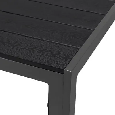 Close-up of the corner of a black outdoor table with a wood-like texture.