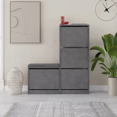 A modern entryway with a shoe cabinet and bench, a large vase, and a piece of abstract art.