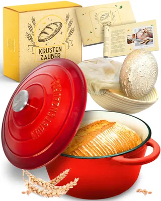 A collection of items for baking bread, including a red Dutch oven with bread inside, a proofing basket with dough, a box, and some wheat stalks.