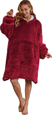 A woman wearing a red oversized hoodie blanket.