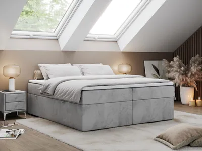 A bedroom scene with a bed, nightstand, and lamps.