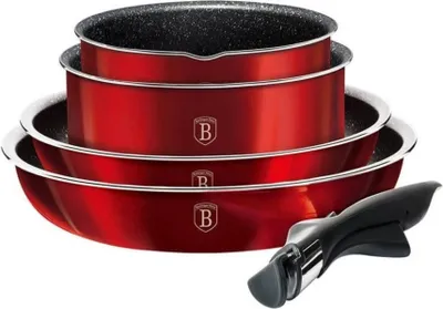 A set of red pots and pans stacked on top of each other, with a black handle detached.