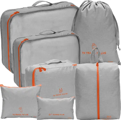 A collection of grey packing cubes and bags with orange zippers and accents, arranged on a white background.