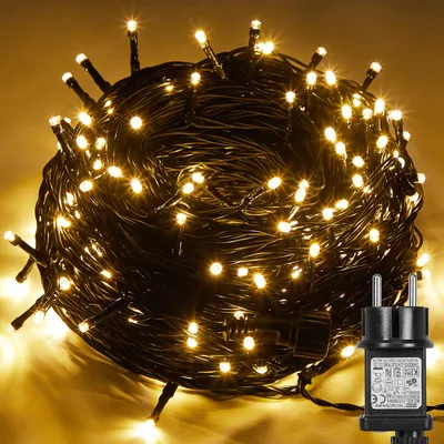 A coiled string of warm white LED lights with a black power adapter.
