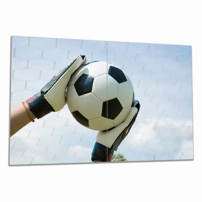 Produktbild von Wallario Herdabdeckplatte aus Glas, Größe 80 x 52 cm 2-teilig, Motiv Fußball - Torwart im Tor vor blauem Himmel