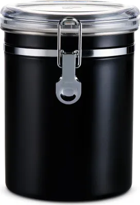 A black metal coffee canister with a clear lid and a silver clasp.