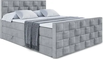 A studio shot of a gray upholstered boxspring bed with a headboard and footboard, set against a white background.