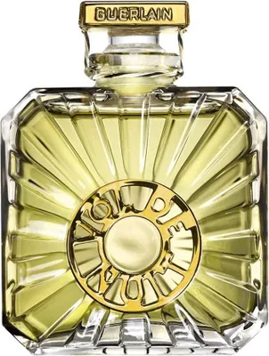 A close-up studio shot of a Guerlain perfume bottle.