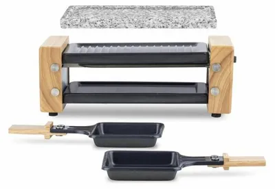 A raclette grill with a granite stone top and two small pans with wooden handles.