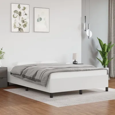 A white bed frame with a gray blanket is shown in a bedroom setting.
