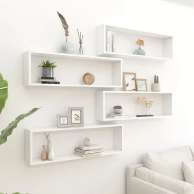 Several white cube shelves are mounted on a white wall, decorated with various small items.