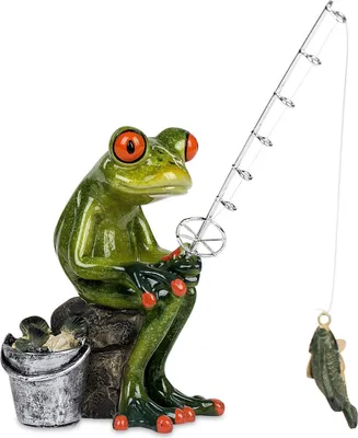 A figurine of a green frog sitting on a rock, fishing with a fishing rod and a caught fish.