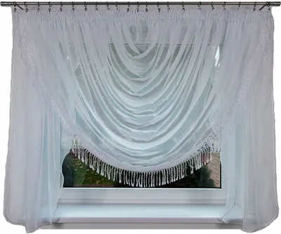 A white sheer curtain with beaded fringe is draped across a window.