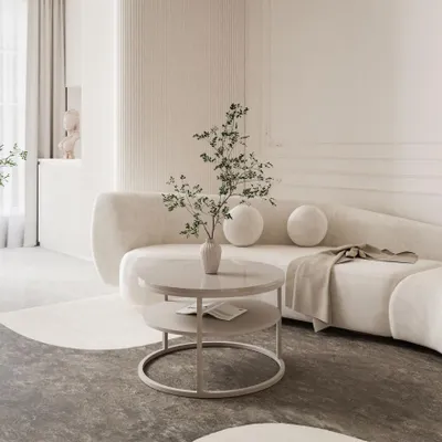 A modern living room with a curved beige sofa and a two-tiered coffee table.