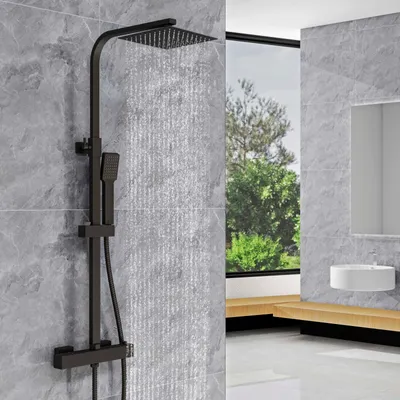 A modern bathroom with a black shower system, a large window overlooking trees, and a white sink.