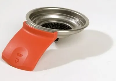 A close-up of a coffee machine filter holder with an orange handle.