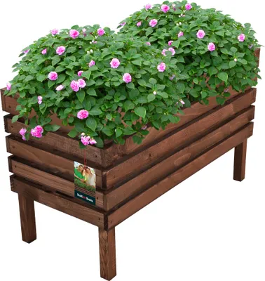 A wooden planter box filled with pink flowers and green foliage, set against a white background.
