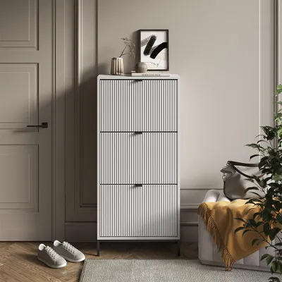 A hallway or entryway with a shoe cabinet, door, and a chair with a blanket.