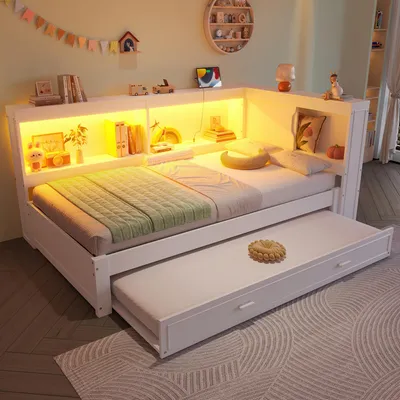 A white wooden bed frame with a pull-out trundle bed, featuring built-in shelving with yellow LED lighting.