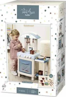 A child playing with a toy kitchen on its packaging.