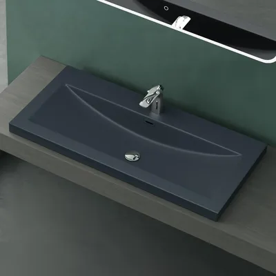 A modern bathroom sink with a faucet, set against a dark green wall and a wooden countertop.