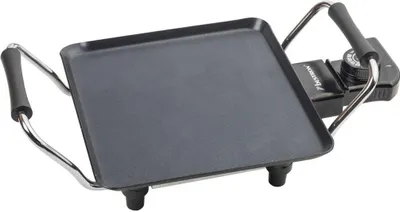 A black electric griddle with silver handles and legs, shown from a diagonal angle on a white background.