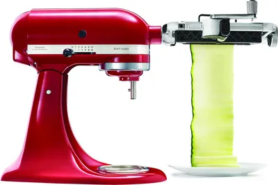 A red KitchenAid stand mixer with a vegetable spiralizer attachment is shown, creating long ribbons of zucchini.