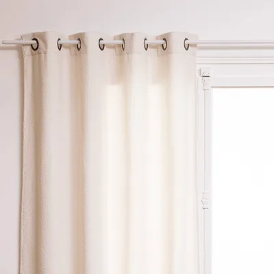 A close-up view of a white curtain hanging from a curtain rod.