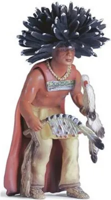 A figurine of a Native American medicine man in traditional attire, holding a fan and a bird.