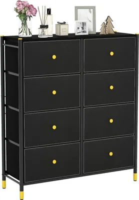 A black fabric dresser with eight drawers and gold accents, displayed on a white background. Decorative items are placed on top of the dresser.