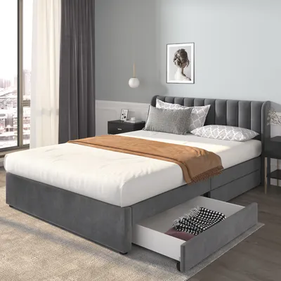 A bedroom scene featuring a grey upholstered bed with storage drawers.