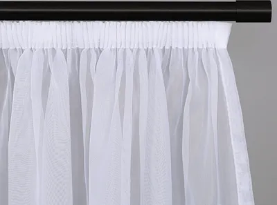 A close-up view of a white sheer curtain hanging from a black curtain rod.