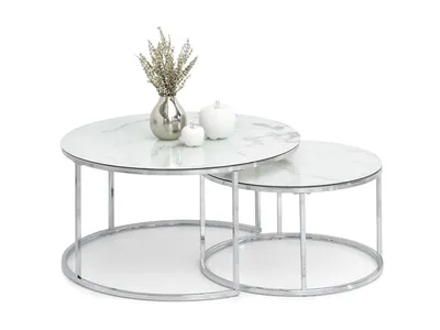 A set of two nesting round coffee tables with white marble-look tops and chrome metal frames, displayed on a white background. Decorative items, including a silver vase with dried flowers and two white decorative spheres, are placed on the larger table.
