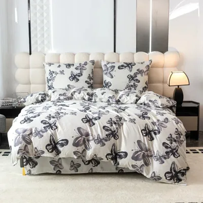 A bed with butterfly-patterned bedding and pillows, set against a tufted headboard.