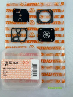 A product packaging with several carburetor repair kit parts laid out on it, with a small plastic container in the foreground.