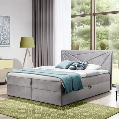 A bedroom scene with a bed, lamp, and window.