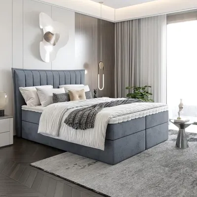 A modern bedroom with a large bed, nightstand, and decorative wall art.