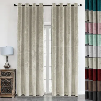 Two beige velvet curtains are displayed hanging from a rod in front of a window. A wooden nightstand with a lamp is visible to the left.